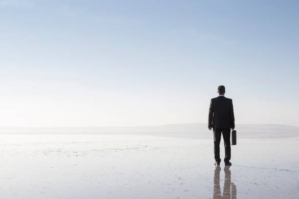 istock Man in black suit on salt lake 878224824