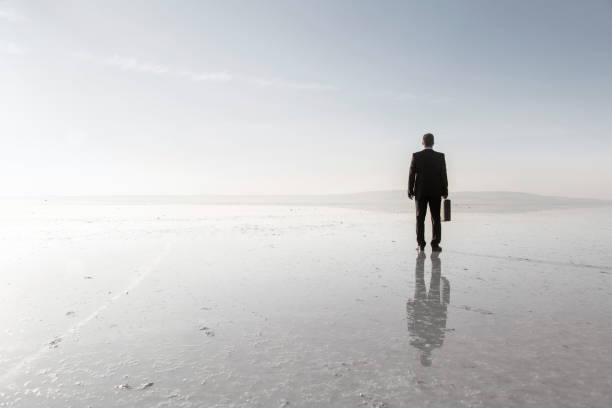 istock Man in black suit on salt lake 878224828