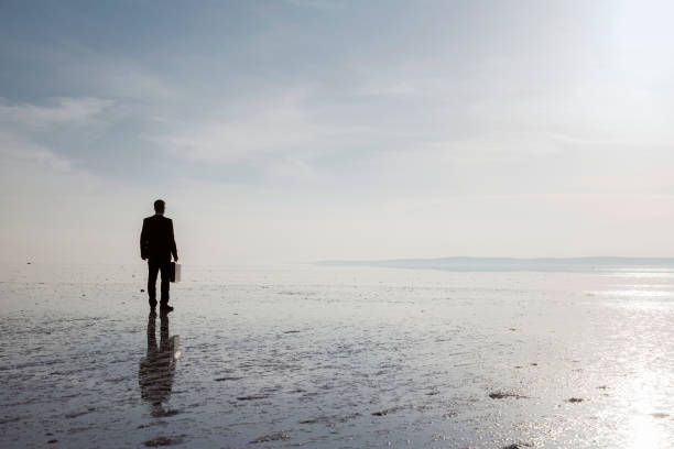 istock Man in black suit on salt lake 878224864