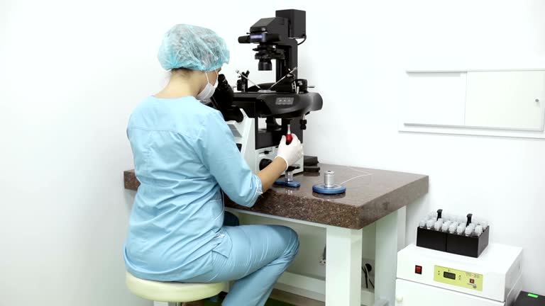 Embryologist perfors ICSI procedure in lab