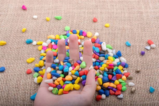 istock Colorful little pebbles in hand and on ground 878239328
