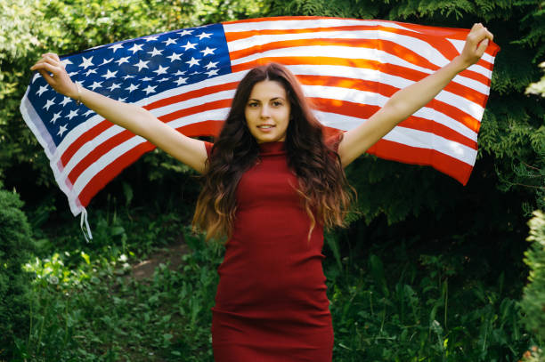 istock girl with a US flag 878239908