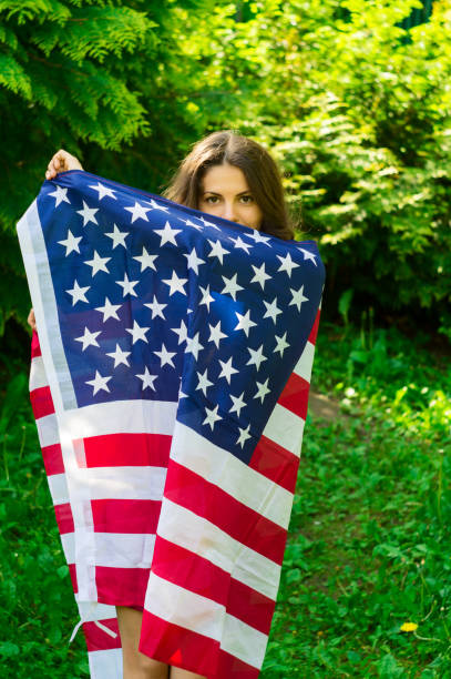 istock girl with a US flag 878239984