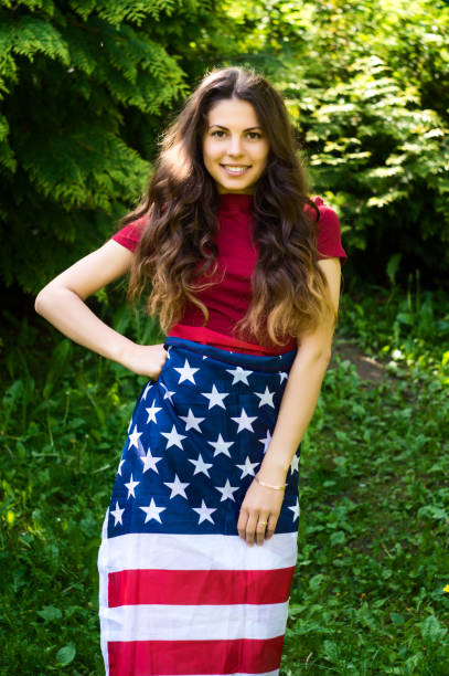 istock girl with a US flag 878245116