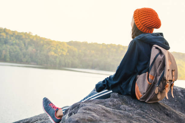 istock Girl Sitting Against Lake And Sky 878246430