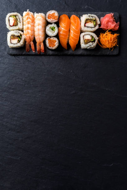 Overhead shot of Japanese sushi on black concrete background stock photo
