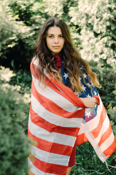 istock girl with a US flag 878257112
