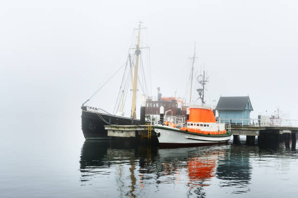 istock A pier with small boats under fog 878257464