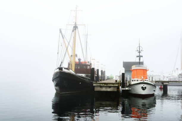 istock A pier with small boats under fog 878257476