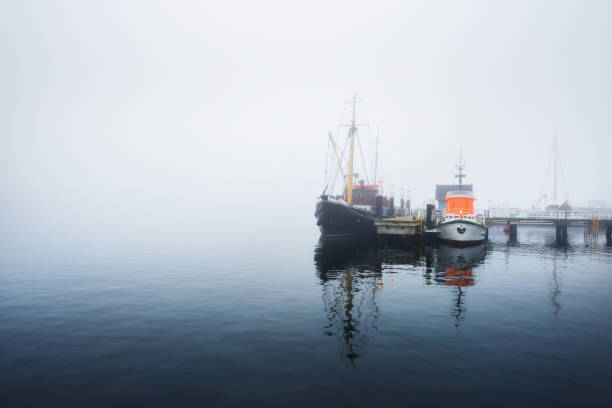istock A pier with small boats under fog 878257480