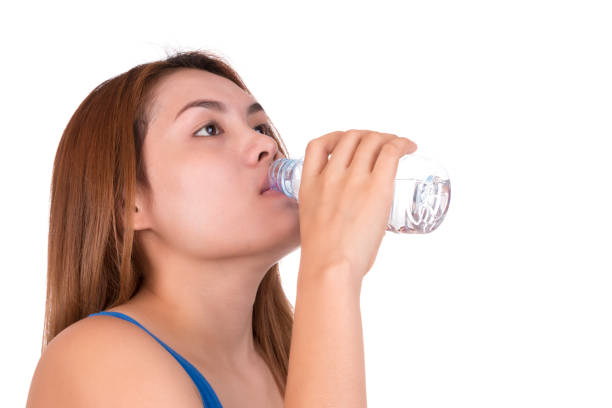 istock Woman drinking bottled water on white background. 878262894