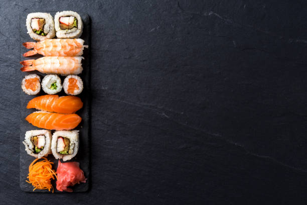 Overhead shot of Japanese sushi on black concrete background Overhead shot of Japanese sushi on black concrete background japanese food stock pictures, royalty-free photos & images