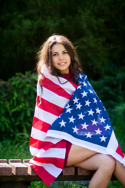 istock girl with a US flag 878265860