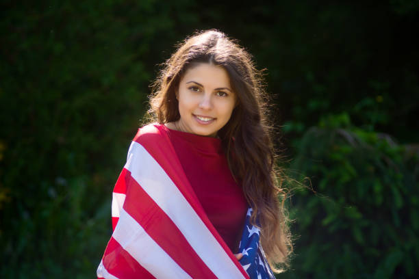 istock girl with a US flag 878269026