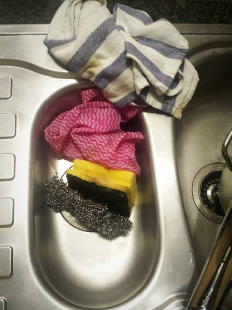 Kitchen sink with dirty tea towel, sponge and bacteria stock photo