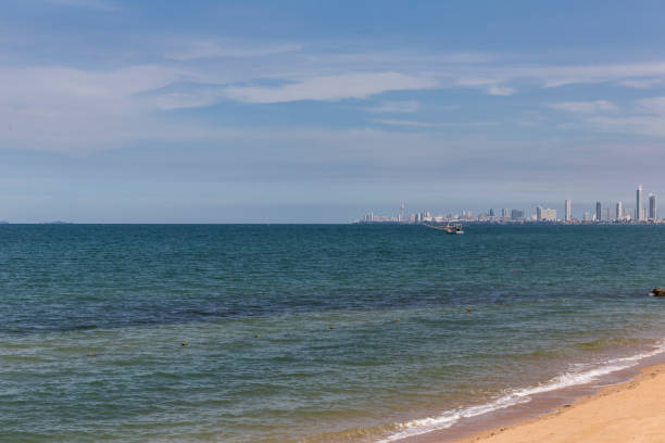 istock Clean and clear water in ocean, with white cloud and blue sky as background at skyline, modern builg in the city. Use as holiday and travel concept. 878280708