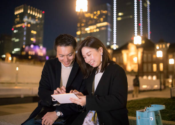 istock Happy young couple watching screen on digital tablet at night 878309594