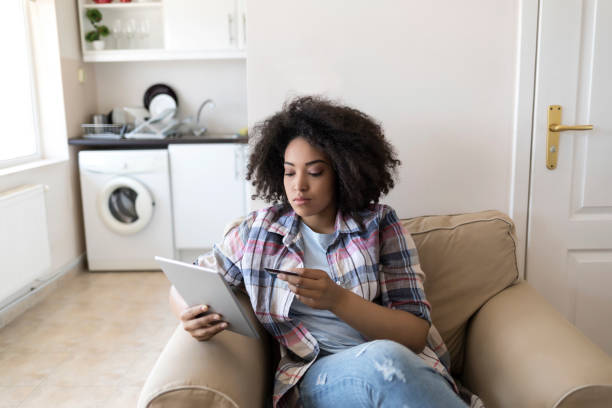 istock Woman using tablet and credit card at home 878311772