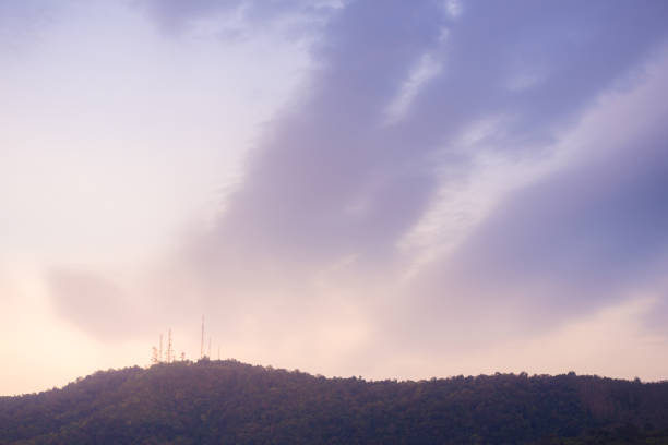 Part of the mountain with telecommunicating antennas on top in the evening, old film filter applied