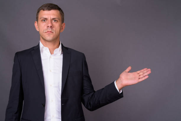 istock Handsome businessman with short hair against gray background 878336364