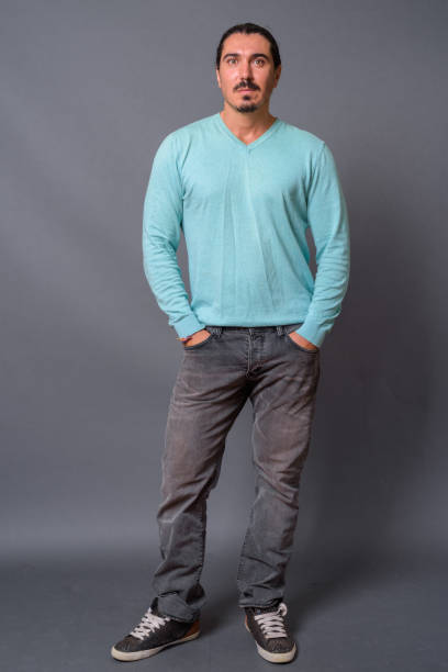 istock Handsome bearded man with long hair against gray background 878346398