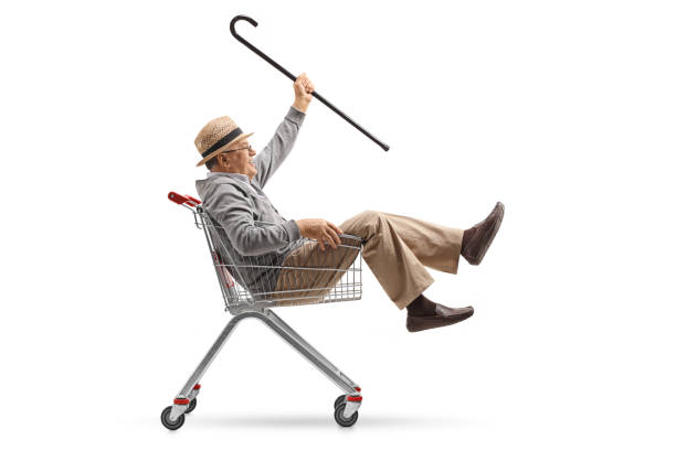 istock Cheerful mature man with a cane riding inside a shopping cart 878346474