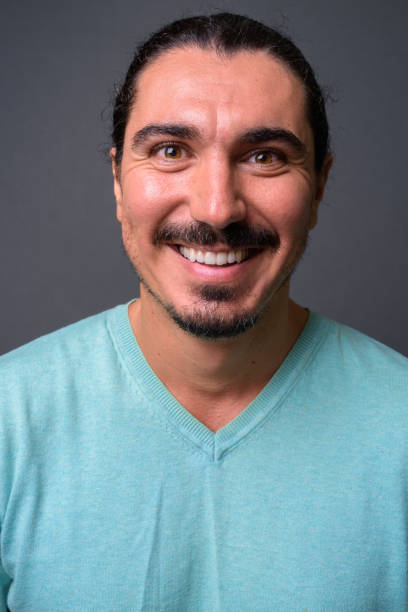 istock Handsome bearded man with long hair against gray background 878346774