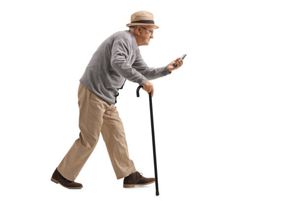 istock Senior with a cane walking and looking at a phone 878347470