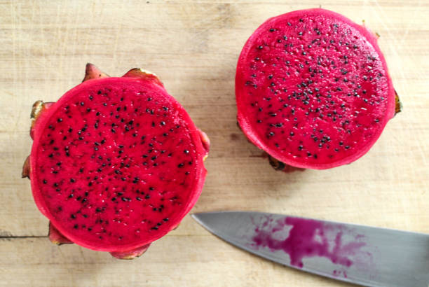 istock Dragon fruit cut in half and knife on wooden background 878349894