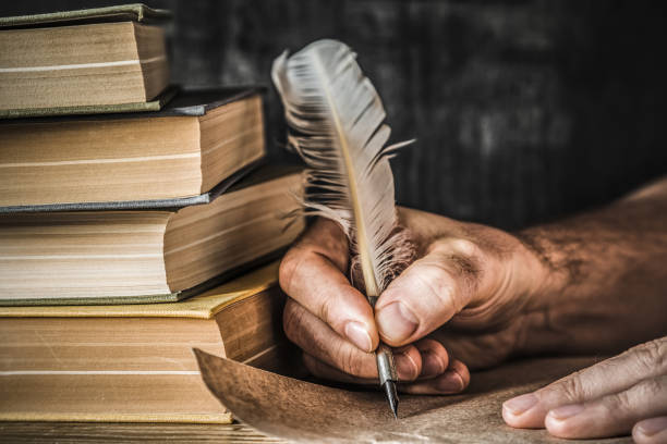 hombre escribiendo una carta vieja. antigua pluma, libros y rollo de papiro sobre la mesa. ambiente histórico. - biografias de autores fotografías e imágenes de stock