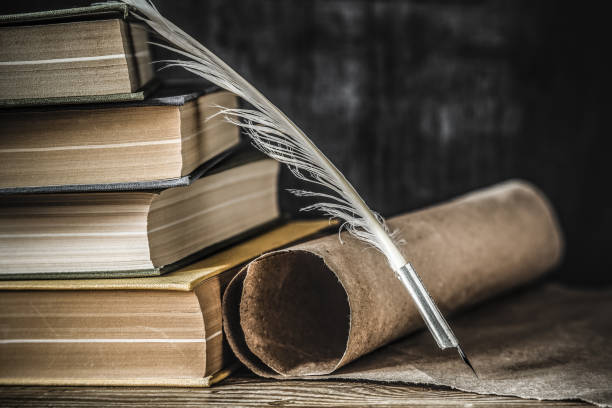 caneta de pena velho com rolo de papel velho e livros sobre a mesa. escrevendo cartas. atmosfera histórica. - ink well paper document quill pen - fotografias e filmes do acervo