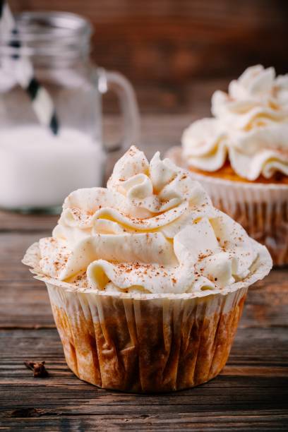 istock Pumpkin cupcakes decorated with cream cheese frosting 878367110