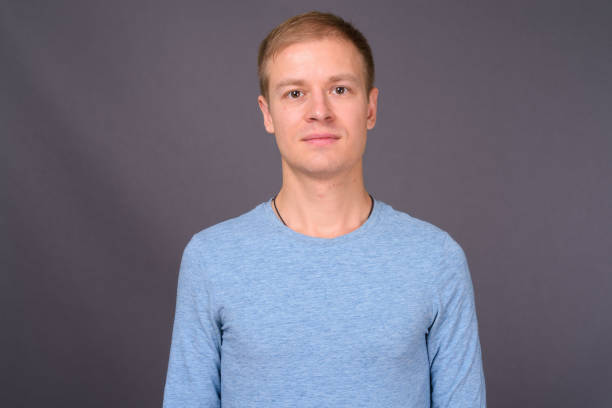 istock Young handsome man with short blond hair against gray background 878368306