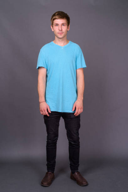 istock Young handsome man wearing blue shirt against gray background 878369100