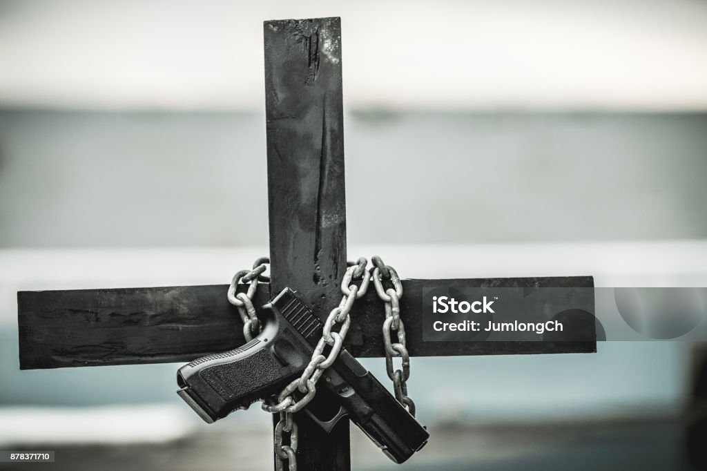 Black cross with a looped chain. Black cross with a looped chain. And juxtapose them with guns. Equipment operators are decorated in the Halloween festivities. Bible Stock Photo