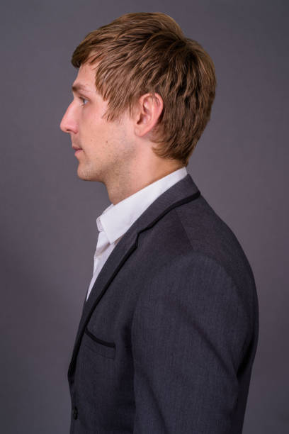 istock Young handsome businessman wearing suit against gray background 878372496