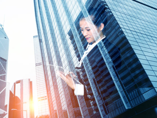 istock Multiple exposure of businesswoman touching digital tablet 878378572
