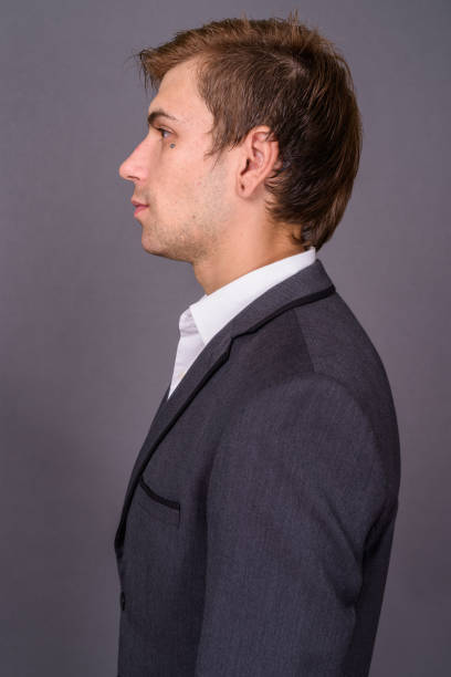 istock Young handsome businessman wearing suit against gray background 878384422