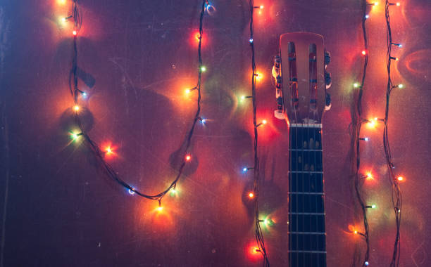 istock Old acoustic guitar with a garland on grunge background, 878384690