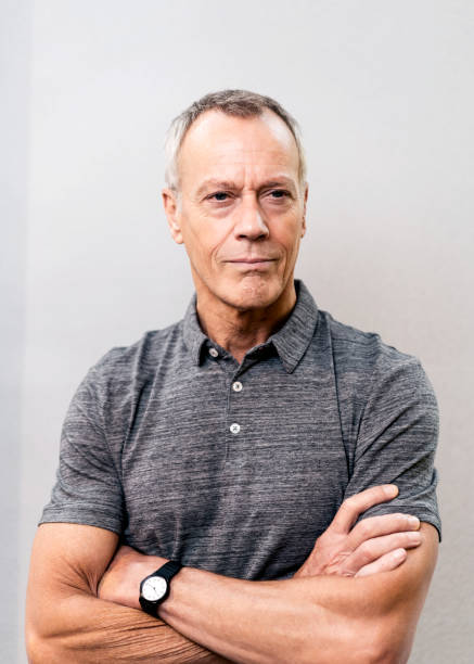 istock Businessman standing arms crossed against wall 878393108