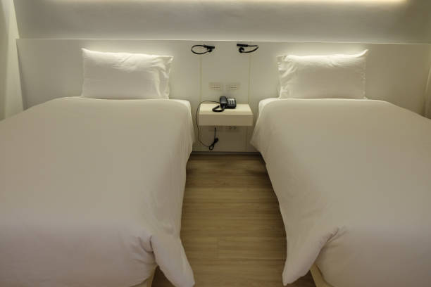 istock White two bed in hotel with wood floor 878395302