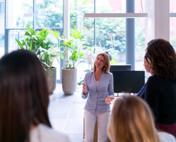 istock Businesswoman discussing with team in office 878401514