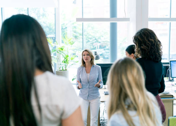 istock Businesswoman discussing with team in office 878401742