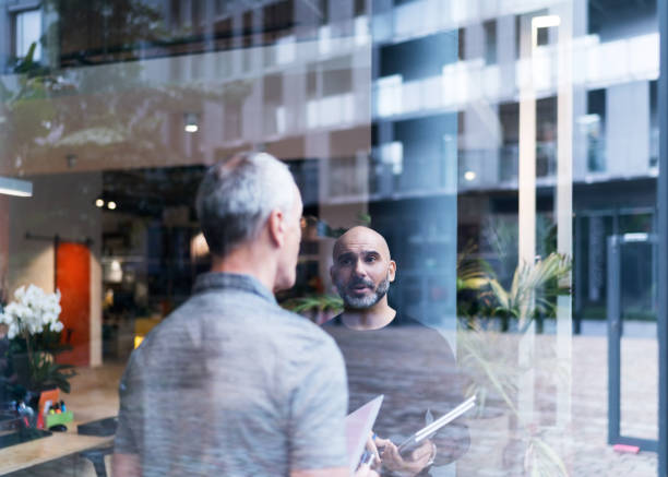 istock Businessman discussing with colleague in office 878401808