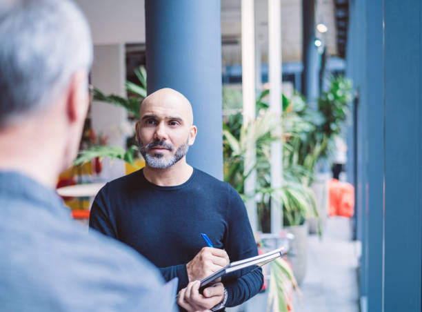 istock Businessman discussing with colleague in office 878401980