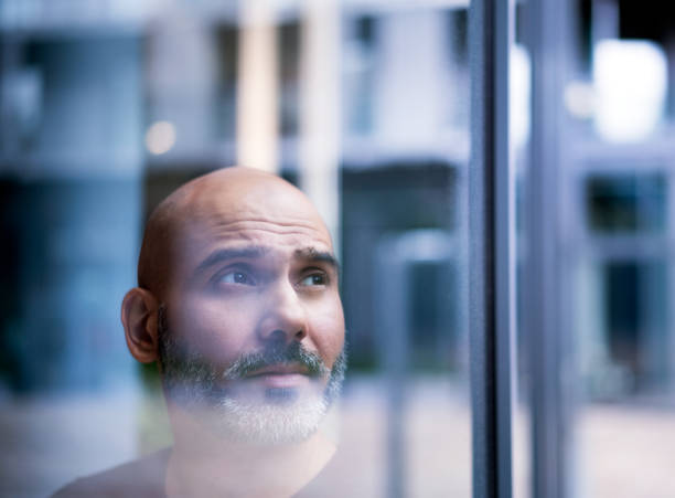 istock Thoughtful businessman seen through window 878402170