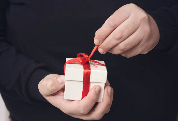 istock A man holding a gift box in his hands 878410196
