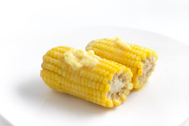 Cooked Corn Cob with butter on white background. Milho verde