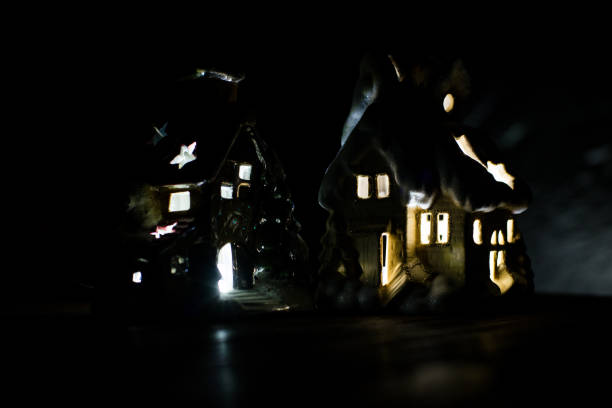 istock Decorative glowing house on a black background. Christmas decorations, a house, snow. 878410336