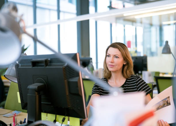 istock Mature businesswoman using computer in office 878415028
